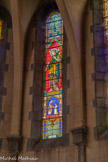 <center> Castellane. </center> L’église du Sacré-Cœur. petite scène : Ordination : un curé tend un calice à un jeune homme agenouillé devant lui ; scène principale : un ange portant du raisin.