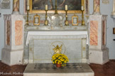 Autel secondaire de saint Jean-Baptiste. L'autel a donc été placé dans l'église entre 1865 et 1869. Il a été restauré en 1989 par Claude, Daniel et Bernard Perez, marbriers.
Ensemble en marbre gris composé d'un autel tombeau adossé, de deux gradins d'autel enserrant un tabernacle ; il porte une décor gravé et doré. L'ensemble est précédé d'un degré d'autel. L'autel est de plan rectangulaire et d'élévation droite, la face est flanquée de deux pilastres qui supportent un entablement légèrement en débord, elle est ornée d'un décor en relief doré. Sur le second gradin, décor rapporté de marbre gris et tables de marbre rose. La face de l'autel porte sur fond de gloire et de nuées, la coquille du baptême posée sur la croix de roseau de Jean-Baptiste et une crosse. 
La porte du tabernacle est identique à celle du maître-autel : une croix émerge d'un bouquet d'épis de blé, un rameau de vigne avec pampres s'enroulant autour d'elle.