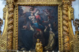 Donation du rosaire, oeuvre d'Antoine Rouvier, datée de 1641. Assise sur une nuée, la Vierge tient l'Enfant Jésus dans son bras droit et remet le rosaire à sainte Catherine de Sienne, tandis que l'Enfant le remet à saint Dominique de Guzman. D'après une quittance (cf. annexe) datée du 11 août 1641, le tableau a été réalisé par Anthoine Rouvier, peintre de Digne, sur la commande des prieurs de la chapellenie de Notre-Dame-du-Rosaire. Vierge à l'Enfant assise sur un rocher, entourée d'angelots dans des nuées. L'Enfant donne un rosaire à saint Dominique agenouillé tandis que la Vierge en tend un autre à sainte Catherine, également agenouillée. A côté de la sainte sont posée un crucifix couché sur un livre avec une tige de lys ; à côté de saint Dominique se trouve un chien couché tenant dans sa gueule deux bâtons enflammés au-dessus d'un livre ouvert, accompagné également d'une tige de lys.