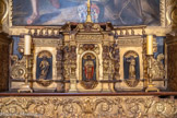 Chapelle Saint Joseph. Gradin d'autel et tabernacle à ailes. Bien qu'ayant été réalisée par une main différente du retable du maître-autel, l'oeuvre a probablement été également sculptée au milieu du 17e siècle. Le gradin d'autel est composé d'une planche de bois horinzontale taillée, dorée et portant un décor gravé sur l'apprêt. Le tabernacle à ailes présente un corps polygonal. Il est composé de cinq travées abritant chacune une niche dans laquelle prend place un personnage sculpté. Une corniche plane et une balustrade couronnent l'ensemble. Le gradin est orné de rinceaux végétaux et de fleurs. Le tabernacle est scandé par cinq termes qui séparent les niches dans lesquelles prennent place, de droite à gauche, saint François, un saint évêque (saint Martin ? sur le côté), le Christ aux liens, saint Pierre (sur le côté) et un saint personnage qui pourrait être saint Paul. Le tout est surplombé par une frise végétale.