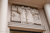 <center>Immeuble de l'ancien Comité des Fêtes</center>Le bas-relief central montre encore une fois deux figures féminines centrales, mais cette fois, celles-ci adoptent une attitude figée et regardent le spectateur de face. Le message est on ne peut plus clair, car elles portent les armes de leur ville respective, ce que confirment les illustrations (à gauche, la façade de la cathédrale Notre-Dame, la partie avant d’une locomotive , ainsi que la façade d’une gare ; et à droite un grand voilier et une végétation luxuriante combinant apparemment vigne et cactus). Au centre, on peut lire les initiales PLM (qui est l’acronyme de la ligne SNCF Paris-Lyon-Marseille). On peut dire sans exagérer que l’image utilise au maximum sa force de persuasion, et que le style est presque sévère, mais il faut reconnaître aussi son efficacité.