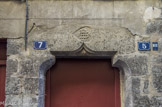 <center>Puget-Théniers</center>Porte à linteau à accolade surmontée d'une monogrammes du Christ entrelacé IHS.