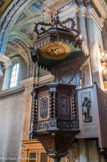 <center>Église Saint-Jean-Baptiste </center>La chaire est couverte de somptueuses boiseries sculptées représentant la vie de St Jean-Baptiste. Elle fait face à la croix.