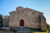 <center>Jouques.</center> Notre-Dame de la Roque. Une seule construction au XIIème : la nef centrale primitive est recouverte d’un toit à deux pentes. A la nef unique, il faut ajouter le clocher, la nef de Saint-Claude au midi effondrée en 1837 suite à un incendie, la nef Sainte-Anne au nord, puis les deux chapelles latérales de Sainte-Madeleine et Sainte-Agathe. Après l’incendie de 1837, on rassemble les deux nefs subsistantes et on raccorde le toit, d’où ce losange visible sur la façade.
Depuis 1861, la chapelle possède un toit unique à deux pentes. La porte actuelle plein-cintre date probablement du XIIIè siècle typique du bâti médiéval.