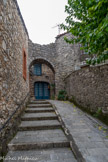 <center>Les Matelles : Porte de la Barre</center>Ouverture récente début XIXe siècle dans les remparts de la 1ère enceinte. Cette porte, entre la Place du Château et la Rampe de la Palissade, est récente. Le porche en pierre de belle facture n’est pas médiéval, il a été construit dans les années 1960-1970 par les Bâtiments de France. Première explication possible pour cette appellation :
La muraille, qui avait perdu toute utilité militaire du fait de l’évolution des techniques, s’était ici effondrée. Le propriétaire du terrain, Jean Avignon, qui possédait deux terrains contigus à la Place du Château, agrandit l’ouverture et l’aménagea de façon à pouvoir passer avec une mule.
Les habitants du quartier trouvèrent plus commode de passer par son terrain, notamment pour avoir un accès plus aisé à l’eau du Puits Neuf situé hors les murs.
Le propriétaire clôtura le passage, cependant il en laissait l’usage aux habitants en leur prêtant la clé ou en laissant ouvert. Seconde explication possible : Au lendemain de la défaite de 1871, les Français prennent conscience de leur insuffisante préparation militaire. Des sociétés de tir se créent.  Les tireurs s’alignaient dos au rempart au-dessus de la Rampe de la Palissade et visaient en direction des collines des Combelles. Par mesure de sécurité on mettait une barre de bois en travers de la rue pendant les heures de tir. Peut-être est-ce l’origine du nom de la porte.