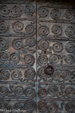 <center>Castelnou : L'église Sainte-Marie du Mercadal. </center>Les deux vantaux, anciens, présentent chacun six traverses horizontales de fer forgé, ramifiées en volutes spiralées. Les espaces libres sont garnis soit de doubles volutes en C, soit de volutes en S de formes et de dimensions variées. L'ensemble est muni de clous à têtes rondes et les traverses du bas sont ciselées.