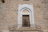 <center>Cathédrale Sainte-Eulalie-et-Sainte-Julie d'Elne</center>Le mur de façade dénué de tout ornement, percé d'un portail roman en marbre bleu de Céret, dépourvu, lui aussi, de toute sculpture ou décoration, est le fruit de plusieurs campagnes de construction. Ses piédroits sont éclatés par le feu. Il s'agit des témoignages de l'attaque des troupes du roi de France, Philippe III le Hardi, en 1285, contre la ville d'Elne.