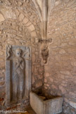 <center>Cathédrale Sainte-Eulalie-et-Sainte-Julie d'Elne</center>Pierre tombale de l'évêque Guillem Jordà (1186) ? C'est probablement sous son épiscopat qu'est entreprise la construction de cette galerie.