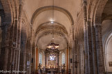 <center>Cathédrale Sainte-Eulalie-et-Sainte-Julie d'Elne</center>L'édifice est composé d'une nef à trois vaisseaux de six travées et terminés chacun par une abside semi-circulaire voûtée en cul-de-four. La nef principale est voûtée en berceau plein cintre, qui tend à devenir brisé vers l'Ouest, attestant les différentes campagnes de construction de l'ancienne cathédrale et de leurs avancées en fonction de l'état des finances de l'évêché. Les piliers sont légèrement penchés vers l'avant et la corniche monte en s'éloignant par-dessus les grandes arcades. Tout ceci fut réalisé par les architectes romans dans le but d'améliorer la perspective.  A l'origine dotés de voûtes d'arêtes, les collatéraux ont été voûtés en demi-berceau lors de l'établissement de la voûte de la nef principale (auparavant charpentée).
Six chapelles voûtées en croisée d'ogives, rajoutées entre le XIIIe siècle et le XVe siècle flanquent le collatéral méridional.