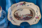 <center>Plat à barbe.</center>Marseille, fabrique Gaspard Robert. Vers 1765-1770.
Faïence stannifère, décor de petit feu polychrome et or.
Don Pierre et Lison Jourdan-Barry, 1995.
Marseille, Château Borély - Musée des Arts décoratifs, de la Faïence et de la Mode, inv. 1995.68.1 et 2
Parmi les faïenciers marseillais, c’est incontestablement Gaspard Robert qui a eu le plus recours au motif des personnages habillés « à la turque ». A cet égard, la pièce la plus spectaculaire sortie de ses fours est une aiguière formant un ensemble avec un plat à barbe.
Grâce au Fonds de dotation du musée Borély, les collections se sont enrichies en 2023 d’une aiguière très similaire avec son bassin de toilette pour dame, présentée dans la salle à manger du midi (salle 9).