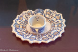 <center>Mancérine</center>Marseille, fabrique Saint-Jean-du-Désert Dernier quart du XVIIe siècle Faïence stannifère, décor en camaïeu de bleu et violet sur fond d’émail bleuté
Collection particulière
Les mancérines sont des porte-gobelets inventés par le marquis de Mancera, vice-roi du Pérou, pour maintenir un gobelet rempli de boisson chaude, principalement de chocolat. L’originalité de la composition s’exprime dans l’association de motifs décoratifs d’inspirations diverses : l’Extrême-Orient pour les cartels et la mythologie gréco-romaine pour le mascaron.