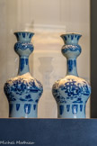 <center>Paire de vases</center>Pays-Bas, Delft. Circa 1690-1720
Faïence, décor de grand feu en camaïeu bleu. Don Marie Grobet, 1919
Marseille, Musée Grobet-Labadié.
La forme bouteille à deux renflements de cette paire de vases est héritée de la céramique d’inspiration turque-ottomane, reproduisant les flasques en métal de type surahi, déclinées dans l’art d’Iznik et reprises par les Chinois à l’époque de la Transition, dans la première moitié du XVIIe siècle. A la demande des marchands hollandais, les potiers d’Arita s’emparent à leur tour de ce modèle pour l’exporter vers l’Europe. Le dessin d’inspiration chinoise est sommaire, souligné en partie par un trait noir, appelé trek. Le bleu profond et l’utilisation du du kwaart (vernis au plomb superposé à l’émail) renvoient à l’âge classique de la faïence delftois.