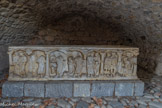 <center>Balazuc.</center>Ce sarcophage de marbre blanc, orné de scènes religieuses, a été découvert au XVIe siècle au hameau des Salles, à deux kilomètres en amont du village, par un agriculteur qui labourait son champ. Sa qualité exceptionnelle indique qu'il s'agit de la sépulture d'un personnage riche et de haut rang. Il est vraisemblablement issu des ateliers d’Arles dont la production de sarcophages au IVe siècle était importante. L'original est conservé au musée gallo-romain de Lyon, on a ici un fac-similé. Les bas-reliefs, malheureusement très abîmés, représentent sept scènes du Nouveau Testament.
1) Le Chris, accompagné par un apôtre, ressuscite le fils de la veuve de Naïm.
2) Daniel, accompagné d’un autre, personnage, empoisonne le dragon
3) Le Christ accompagné par un apôtre guérit le paralytique.
4) Le Christ annonce à saint Pierre son triple reniement.
5) Le Christ guérit un enfant aveugle de naissance. 
6) Deux soldats romains s’apprêtent à procéder à l’arrestation de saint Pierre.
7) Saint Pierre, évangélisateur, enseigne un rouleau des Ecritures dans les mains.