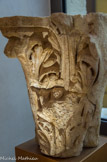 <center>Le Musée d'Art Sacré du Gard. </center> Les lobes des feuilles d'acanthe de cette corbeille, comme des deux autres, présentent une particularité. Ils sont séparés par une trouée verticale et étroite, une sorte de fente obscure, divisée en deux parties superposées par une barre transversale. La répétition du motif en fait une signature d'artiste. Une telle caractéristique a été signalée par A Borg, qui la désigne comme une « goutte d'ombre », signature du sculpteur de la galerie occidentale du cloître de la cathédrale Saint-Sauveur d'Aix-en-Provence, vers 1190. Il retrouve le travail de ce sculpteur dans le porche de l'église Notre-Dame du Thor, près d'Avignon.