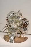 <center>Niki de Saint Phalle, Jean Tingurly</center>Le Cyclop - La Tête 1986.
Maquette : métal, miroir sur polyester renforcé de fibre de verre Museum Tinguely, Bâle/un engagement culturel de Roche Donation Niki de Saint Phalle. <br> C’est à la reprise des travaux du Cyclop, en 1987, après plusieurs années d'interruption, que Niki de Saint Phalle met en œuvre son projet de recouvrir de miroirs la Face en béton du « Monstre ». Elle avait imaginé auparavant soit de la peindre, soit de la réaliser en céramique, ou encore de la laisser à la végétation grimpante. L'idée des miroirs lui vient de son travail pour le Jardin des Tarots en Toscane, le grand œuvre auquel elle se consacre depuis la Fin des années 1970. Les milliers de tesselles pour Le Cyclop ont été spécialement découpées en fonction du modelé de la tête et posées quatre années durant par les collaborateurs de l’artiste.