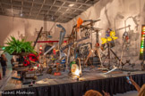 <center>Jean Tinguely</center>L'Enfer, un petit début 1984 [Hell, a Small Beginning]
Métal, objets et matériaux divers, moteurs électriques Centre Pompidou, Musée national d'art moderne, Paris Achat, 1990. <br>
Reconfigurée par Tinguely à chaque présentation, cette œuvre spectaculaire est acquise par le Centre Pompidou en 1990 suite à la rétrospective de l'artiste. Animée de mouvements désordonnés, elle est constituée d'une kyrielle d'éléments bricolés et de toutes natures allant de la tête d'élan naturalisée à la plante verte, en passant par toutes sortes de roues et de percussions. Elle témoigne des nouvelles préoccupations de l'artiste, apparues peu de temps auparavant dans des retables à connotation « satirique et canularesque » où il introduit notamment des crânes d'animaux pour signifier « la mort qui nous fait des grimaces ».