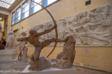 <center>Héraklès archer</center>Modèle à grandeur d’exécution
1909 et 1923
Plâtre
Don Cléopâtre Sévastos Bourdelle et Rhodia Dufet Bourdelle, 1949. <br>
Au Salon de la Société nationale des beaux-arts de 1910, Héraklès archer fait une entrée triomphale dans l’histoire de l’art moderne. L’exploit du héros n’a d’égal que la prouesse de la construction plastique, tendue au-dessus d’un vide béant. Ce chef-d’œuvre devait être une pièce unique. Devant l’engouement général, son commanditaire, Gabriel Thomas, restitue à Bourdelle son bronze et son droit d’édition. Après 1920, le sculpteur réalise deux variantes de la version initiale. Cette seconde version se distingue par deux bas-reliefs sur le rocher : L'Hydre de Lerne et Le Lion de Némée.