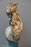 <center>Méduse</center>Marteau de porte
Exposition des Arts décoratifs de 1925 Plâtre
Legs Rhodia Dufet Bourdelle, 2002. <br>
L’art « fin de siècle » réactualise la figure archaïque de Méduse à la chevelure de serpents. Ce marteau de porte résulte d’une commande pour le pavillon de la maison de serrurerie Fontaine, à l’Exposition internationale des arts décoratifs et industriels modernes de 1925. Bourdelle imagine la main de Persée montée sur charnière, tenant les tresses de serpents de la tête tranchée, « afin que le chef heurte en retombant le bouclier du héros ». Quand chaque coup de heurtoir réitère le geste fatal et sanglant…