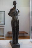 <center>Madeleine Charnaux</center>Grande étude définitive 1917
Bronze, fonte Godard
Legs Rhodia Dufet Bourdelle, 2002. <br>
La silhouette gracile de Madeleine Charnaux inspire à Bourdelle plusieurs études. « Contenir, maintenir, maîtriser » : la formule lapidaire du maître trouve son expression manifeste dans l’épure de figures où les jambes se résument à un parallélépipède, le buste à un trapèze, la tête à un masque triangulaire sur la base cylindrique du cou. Nourrie du « primitivisme » des idoles des Cyclades et des statues-colonnes médiévales, elles anticipent les recherches d’Alberto Giacometti.