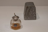 <center>Paul Poiret, la mode est une fête</center>Raoul Dufy 1877-1953
Henri Alméras 18951-1965, parfumeur.
Les Parfums de Rosine. Parfum Le Fruit défendu et sa boite
Verre, métal, cartonnage et papier
Palais Galliera — musée de la mode de la Ville de Paris.
