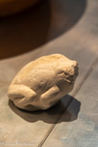 <center>FIGURINE DE GRENOUILLE</center>Période pré ou protodynastique, fin du IVe millénaire av.n.è.
Découverte à Tall al-Sakan, 1999-2000.
Les figurines animales en pierre sont assez fréquentes en Égypte prédynastique, alors qu'à la même époque au Proche-Orient on trouve essentiellement des figurines en terre cuite représentant des moutons, des chèvres, des bœufs ou des ânes.