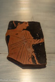 <center>TESSON ATTIQUE À FIGURE ROUGE (FRAGMENT DE SKYPHOS?): PARTIE SUPÉRIEURE D'UN PERSONNAGE MASCULIN</center>Production grecque de l'Attique, période perse, Ve siècle av.n.è.
Découvert à Gaza, Blakhiya (antique Anthédon)
Céramique.
La céramique attique fut découverte en grand quantité sur le site de Blakhiya. Plus de 2000 tessons furent identifiés. Son étude a permis de mettre en évidence le quasi-monopole des importations de céramiques fines originaires de l'Attique pendant toute la période perse. La céramique attique supplée, dès la fin du VIe siècle av.n.è., celle en provenance des îles Egée et de l'Asie Mineure.