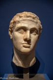 <center>Buste de Ptolémée XII Néos Dionysos (117-51 av. J.-C.)</center>Époque ptolémaïque, Ier siècle av. J.-C.
Égypte
Marbre
Paris, musée du Louvre, département des Antiquités grecques, étrusques et romain. <br>
Le roi porte un bandeau au sommet du front, caractéristique de l’iconographie du dieu grec Dionysos, auquel il est ici officiellement assimilé en tant que « Nouveau Dionysos » (Néos Dionysos). Les souverains ptolémaïques étaient considérés comme des dieux et des déesses vivantes auxquels u culte devait être rendu à dates fixes.