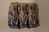 <center>Pot à kohol</center>(fard noir à yeux) décoré de dieux Bès
Période ptolémaïque Faïence
Genève, Fondation Gandur pour l’Art.