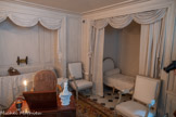 <center>Salle de bains.</center>Lit de repos en bois laqué gris, à dossiers égaux en forme de médaillons sculptés de frises de rubans et d'écoinçons à décor de fleurons, les traverses et la ceinture ornées de rais-de-coeur, interrompus par des dais de raccordement cubiques à rosaces, reposant sur huit pieds fuselés cannelés et rudentés. 1775-1785. Jean-Baptiste Lelarge III (1743-1802) est reçu maître en 1775. Issu d'une famille d'ébénistes, il produit de nombreux sièges pour une clientèle variée, comptant notamment le roi du Portugal.