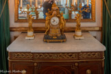 <center>Chambre d'apparat de Mme Thierry de Ville d'Avray.</center>Pendule. Gros. 1750-1799. Pendule formée d'une colonne de marbre en marbre rose, surmontée d'un vase fleuri, et reposant sur une imposante base carrée agrémentée d'un bas-relief en bronze doré figurant un décor de putti évoluant parmi des instruments d'observations astronomiques.
Au centre de la composition, le cadran est flanqué de deux figures féminines à la poitrine découverte, tressant des guirlandes de fleurs. L'ensemble repose sur une terrasse à degrés soulignée par une frise en bronze doré.