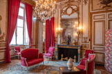 <center>Chambre sur cour.</center>Canapé d’une paire, réalisé dans l’atelier de Jean-Baptiste Lebas (1729-1795), menuisier-ébéniste reçu maître en 1756. Canapé à garniture de soie rouge brochée à motifs de cartouches formés de guirlandes de feuillages, reposant sur six pieds galbés ; haut dossier cintré comportant à la clef un cartouche en forme de rosace d’où s’étendent de part et d’autre des feuilles. Les encadrements moulurés comportent des rangs de perles ou des tresses. Dés à rosaces à la jonction entre les pieds et la traverse, ainsi que dans les parties entre les pieds.