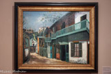 <center>Musée de Montmartre</center>MAURICE UTRILLO (1883-1955)
L’Ancien Maquis à Montmartre, vers 1919
Huile sur toile
Musée de Montmartre, collection Le Vieux Montmartre Ancienne collection Pierre Levasseur Acquisition par préemption, 2018.<br>
Le maquis, vaste terrain vague situé entre le Moulin de la Galette, la rue Caulaincourt, et le Lapin Agile, disparaît au profit de l’urbanisation de Montmartre dans les années 1910. Utrillo rend ici un hommage à son ancien quartier, par la vivacité des couleurs et la précision de la composition. Le sujet est caractéristique des réflexions de l’artiste sur le pittoresque comme modalité d’expression de la modernité et de son identification personnelle à la décrépitude qu’il dépeint.