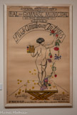 <center>Musée de Montmartre</center>SUZANNE VALADON (1865-1938)
Bal au Gymnase : L’Aide Amicale aux Artistes, 1927
Lithographie
Weisman & Michel Collection.<br>
Valadon réalise cette lithographie pour l’affiche du bal caritatif organisé par l’Aide Amicale aux Artistes, association active pendant une dizaine d’années à partir de 1921 qui finance les artistes par un système d’achat anticipé de leurs œuvres. Les affiches, réalisées par des artistes membres comme Othon Friesz ou Foujita, sont habituellement à l’image des bals annuels, festifs et hauts en couleurs. Valadon choisit ici la sobriété du modèle nu qui adopte la pose du contrapposto, ce léger déhanché originaire des sculptures antiques. Valadon a pu s’inspirer de sa carrière de modèle puisqu’elle a elle-même posé ainsi à plusieurs reprises. Le jeu de miroir entre cette figure anonyme et l’artiste va plus loin : avec sa palette et les fleurs qui jaillissent de son pinceau, le modèle est devenu peintre sous nos yeux tout comme Valadon.