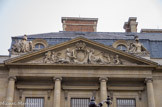 <center>Le Palais Royal.</center> Le fronton en pierre couronnant le pavillon ouest du Palais-Royal, abritant le Conseil d’Etat, donnant sur la Place du Palais Royal représente La Force et la Justice. C’est l’œuvre d’Augustin Pajou (1730-1809) qui l’a exécutée en 1765.