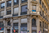 <center> La Presse. </center> Le bâtiment du 116, rue Réaumur, en pierre de taille, à l’éclectisme tardif, arborant une foisonnante richesse décorative, fut construit en 1897 par l’architecte Albert Walwein (1851-1916), pour la maison Storch, fabricant de flanelle et molleton. Il fut primé au concours des façades de la ville de Paris en 1898.
Seuls le rez-de-chaussée et l’entresol conservent leur état d’origine. Au-dessus de la porte d'entrée, de puissantes sculptures d'atlantes drapés dans des peaux de lion et engainés dans une volute reposant sur le mufle de l’animal, soutiennent la corniche supérieure. Un fronton, bas relief à sujet mythologique (Diane avec deux amours), néo rocaille avec caducées (Mercure, le commerce) et cornes d’abondance.