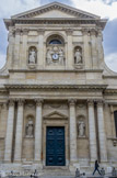 <center>Chapelle Sainte-Ursule de la Sorbonne. </center> Porte extérieure.  Dans la lignée des églises baroques, la façade présente deux rangs de colonnes superposées d'ordre corinthien, et d'ordre composite, bordés à l'étage par deux volutes. Elle est ornée de quatre niches comportant chacune une statue. La fenêtre centrale a été modifiée au XIXe siècle pour incorporer une horloge surmontée des armes du cardinal et tenue par deux muses.