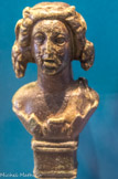 <center>Applique de trépied </center> Elle est en forme de buste de Bacchus. Bronze. Ier - IIe s.
