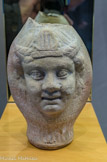 <center>Vase anthropomorphe </center> Il est composé d'une tête d'Amour vendangeur d'un côté et d'une tête de jeune personnage couronné de l'autre. Céramique. Proviendrait de Cnide (Turquie). Milieu du Ier - milieu du IIe s.