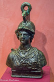 <center>Poids de balance</center>Il a la forme d'un buste de Minerve, la déesse de la guerre mais aussi du commerce. Elle porte le casque à cimier, une tunique agrafée sur l'épaule droite par une fibule et son attribut, l'égide ornée de la tête de Méduse. L'ornement du casque a été astucieusement recourbé en anneau de suspension. Bronze (poids), plomb (à l'intérieur). Époque romaine