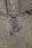 <center>Cloitre de St Trophime</center>galerie Nord. Console représentant la tarasque, monstre androphage tenant entre ses pattes un personnage aux cheveux bouclés. Doubleau d'angle chanfreiné.