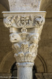 <center>Cloitre de St Trophime</center>galerie Nord. Chapiteau à deux rangs de feuilles d'acanthe surmontés par deux têtes humaines et deux têtes de griffons.