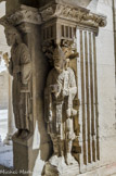 <center>Cloitre de St Trophime</center>galerie Nord. Ce pèlerin porte le bâton de pèlerin en tau et la gourde du pèlerin ; Il est chaussé de sandales ; il est coiffé d’un bonnet avec une coquille, évocation du pèlerinage à Saint-Jacques-de-Compostelle dont Arles était une étape.