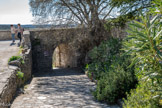 <center> Lussan.</center> Porte des Pauses.
Cette entrée sud, opposée à l'entrée principale près du château, constitue la deuxième entrée du village.
Elle est desservie par un chemin qui longe les remparts avant de rejoindre la route d’Uzès au niveau du pont sur l’Aiguillon.
Pour certains, le nom de pause évoque la halte que l’on observait au faîte de la montée pour reprendre haleine. Pour d’autres, pause renvoie aux périodes de trêve car cette porte restait ouverte dans les périodes calmes et fermée si une menace était annoncée.