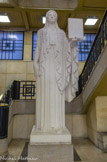<center> Tribunal de Commerce. </center> Statue de Thémis, déesse de la justice de la loi et de l'équité sculptée en 1933 par Henri Raybaud. Cette allégorie inspirée des koré de la statuaire grec archaïque, tient dans sa main gauche la loi, sa main droite posée sur un glaive.
