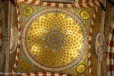 <center>Coupole proche de l’entrée.</center>Les fleurs sont rouges, pour rappeler le premier martyr, Saint Etienne. Coupole évoquant l'ère des prophètes. Dans les pendentifs : la vigne chargée de raisins, le lys entre les épines, rameau d’olivier aux feuilles d'argent, le palmier chargé de fruits. Avant le XVIe siècle, beaucoup de marins  allaient prier devant la statue de Notre-Dame de la Mer dans l’église Saint-Etienne située là où se trouve actuellement l’église Notre-Dame du Mont. Mais, en 1588, cette église fut démolie et les marins prirent alors l’habitude de venir à Notre-Dame de la Garde pour y prier et y déposer de nombreux ex-voto.