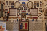 <center> Ex-voto de la chapelle de saint Roch. </center>Les murs des chapelles latérales sont couverts d'un premier niveau de plaques de marbre. La partie supérieure des murs de ces chapelles latérales est occupée par des ex-voto peints placés sur plusieurs rangées superposées. Les ex-voto (« d’après le vœu » en latin, objets offerts à la Vierge ou à un saint après une intercession et/ou un miracle) sont nombreux et variés à Notre-Dame de la Garde. On peut trouver des plaques de marbre, la maquette d’un bateau ou d’un avion, et des images pieuses ou des statuettes.