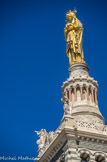 <center>Notre-Dame de la Garde.</center> Sur la terrasse de la tour carrée s'élève un campanile cylindrique d'une hauteur de 12,5 mètres comportant seize colonnes de granit rouge sur lequel est posée la monumentale statue de la Vierge.