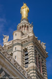 <center>Notre-dame de la Garde.</center>Plaqué contre la façade sud de ce clocher, un escalier octogonal permet d'accéder à la terrasse et de là à l'intérieur du campanile et de la statue.