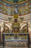 <center>La basilique.</center> Le maître autel conçu par Révoil, réalisé par Jules Cantini entre 1882 et 1886, est en marbre blanc avec un soubassement formé de cinq arcatures en bronze doré reposant sur des colonnettes en lapis-lazulis avec un décor de mosaïques. Derrière l'autel se dresse une colonne de marbre rouge supportant un chapiteau d'orfèvrerie sur lequel est posée la statue de la Vierge.