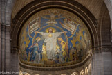 <center>Basilique du Sacré-Cœur de Montmartre </center>   
De chaque côté, sur deux rangs sous des architectures dorées, l’hommage de l’Eglise (à gauche) et de la France (à droite) au Sacré-Cœur. L’Eglise du Ciel est placée au « deuxième étage » de la mosaïque, entourant le plafond du chœur sur lequel est représentée de manière figurée la Sainte Trinité (au-dessus du Christ, colombe de l’Esprit Saint et visage du Père qui tient et bénit le monde), sur deux rangs : les Saints qui sont particulièrement liés au Sacré-Cœur de Jésus (à gauche) et les Saints de France (à droite). A la base de cette mosaïque court en latin la formule qui illustre la construction de la Basilique comme un don de toute la France au Cœur du Christ : « Au Cœur Sacré de Jésus, la France fervente, pénitente et reconnaissante ».